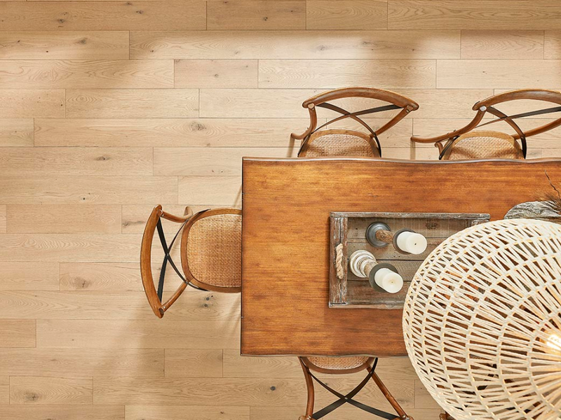 DIY laminate flooring adds a natural look to a dining room featuring a rustic table and chairs.